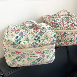 Close-up of quilted floral makeup bags showing the soft cotton texture and top handle