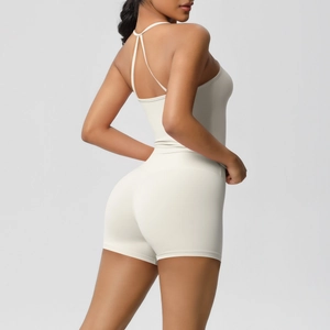 Close-up of cream yoga set showing cross-back sports bra and high-waisted shorts detail