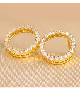 Macro detail of gold circle stud earrings featuring paved cubic zirconia stones