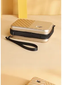 Detail view of champagne gold mini hard shell suitcase bag with Forever Young metal plate