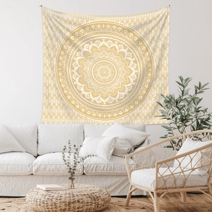 Detail of bohemian mandala tapestry in mustard yellow on a white wall in living room