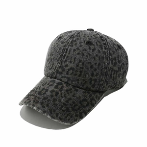 Detail view of the washed denim baseball cap with grey leopard print and curved brim