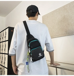 Detail of water-resistant black and green crossbody chest bag with checkered pattern