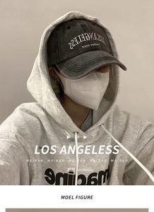 Close-up of vintage washed grey cotton baseball cap with embroidery on a street style model