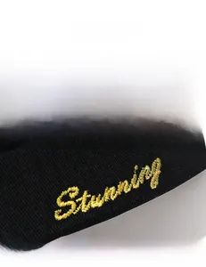 Détail macro de la broderie jaune Stunning sur le tissu noir du bonnet