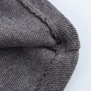 Primer plano de las costuras detalladas y la textura de punto gris oscuro del top de mujer