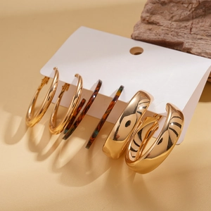 Detailed view of 3-pair earring set featuring gold hoops and tortoiseshell texture