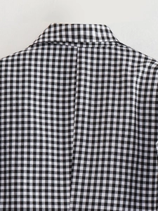Close-up of black and white gingham blazer fabric showing high-quality woven texture