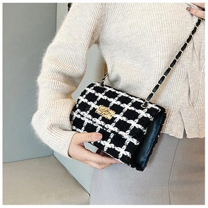Detail of classic black and white tweed chain bag with gold square buckle and texture