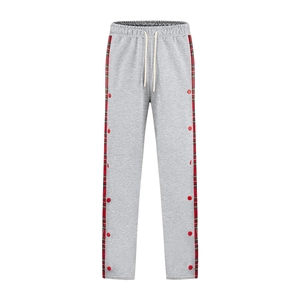 Detailed view of gray trousers with red-green plaid side tape and decorative buttons