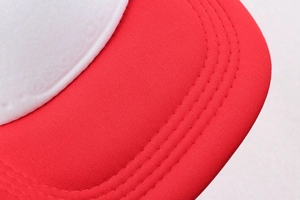 Close-up of red brim and white stitching detail on a beach-themed baseball cap