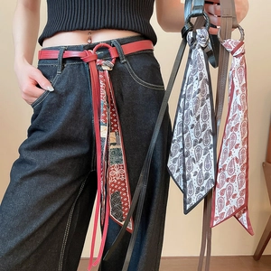 Close-up of leather belt with vintage silk scarf fringe and paisley floral patterns
