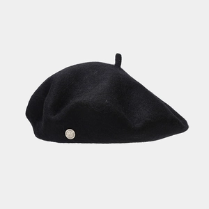 Detail of wool beret showing the smooth felt texture and silver metallic logo engraving