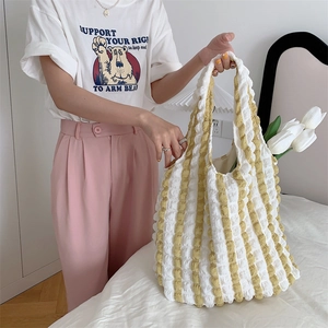 Detail of yellow and white striped bubble texture tote bag in a cozy home setting