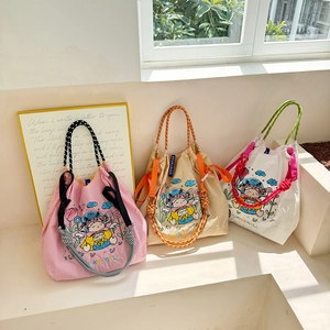 Detailed macro view of embroidered canvas tote bags with drawstring and woven handles