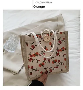 Close-up of orange floral woven tote bag with a wooden button and cotton rope handle