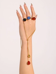 Detail of adjustable 18K gold plated necklace with teardrop charms and gemstone rings
