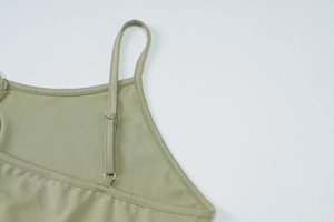 Detailed close-up of olive green camisole with adjustable metal strap buckle and fine stitching