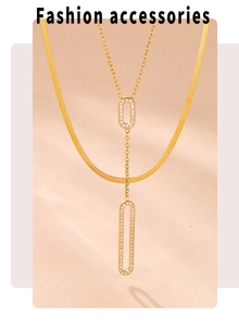 Detail of layered gold necklaces featuring a flat snake chain and pavé rectangular pendants