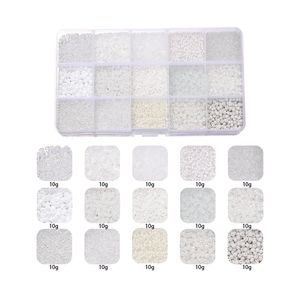 Macro detail of 15-grid DIY bead set with white and clear glass beads for jewelry making