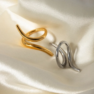 Abstract 18k gold and silver stainless steel rings with fluid lines on silk fabric