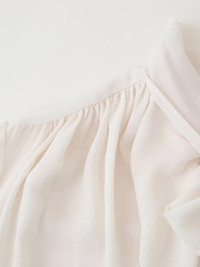 Macro detail of breathable white chiffon fabric showing elegant pleats and texture