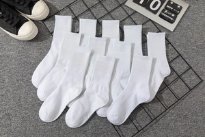 Detailed close-up of white crew socks with rib-knit cuffs and black lettered slogans