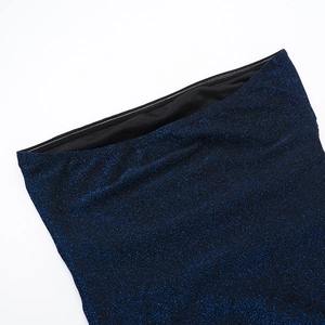 Détail du tissu à paillettes bleu scintillant avec doublure noire sur une robe ajustée