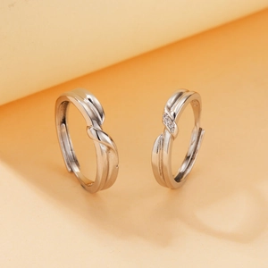 Macro view of adjustable silver couple rings with twisted design and zircon inlay details