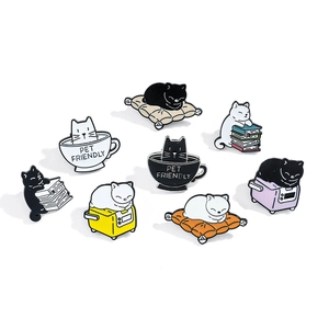 Set of 8 cute cartoon cat enamel pins featuring black and white kittens reading and sleeping