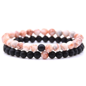 Close-up of 6mm distance bracelets with orange-white textured and matte black beads