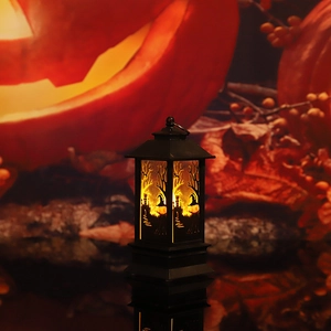 Detail of Halloween witch silhouette lantern with warm yellow light on a dark surface