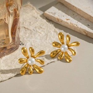 Vintage floral pearl stud earrings in gold finish on an elegant textured paper background