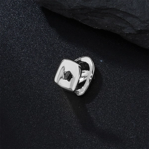 Close-up of silver hip hop grillz with star cutout on black stone background