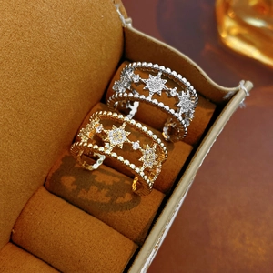Close-up of gold and silver double-layer star rings with zircons in a jewelry box