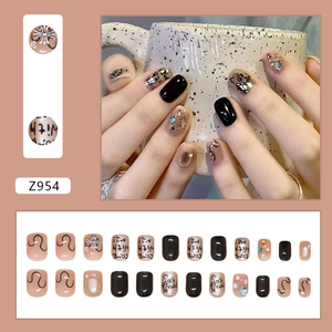 Punk style short press-on nails with black graffiti and 3D rhinestones on cinnamon background