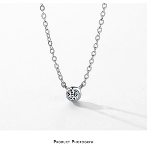 Macro shot of polished S925 silver necklace featuring a bezel-set zircon pendant