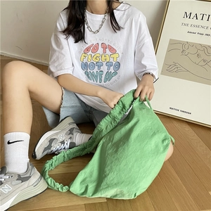 Dettaglio borsa a sacchetto in nylon verde con manico arricciato e coulisse interno