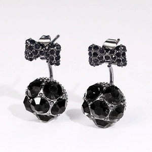 Pendientes de lazo de cristal negro con colgantes de esferas de strass en fondo blanco
