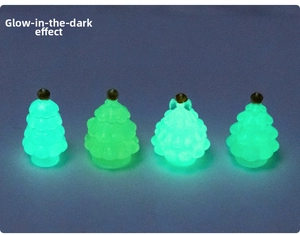 Close-up of four mini luminous Christmas trees glowing in the dark for DIY decor
