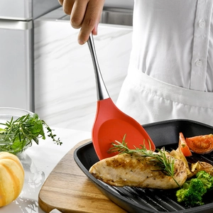 304 stainless steel spatula with red silicone head used for frying in a non-stick pan