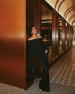 Close-up of elegant off-shoulder knit maxi dress with long sleeves in premium black