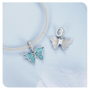 Macro detail of a 925 sterling silver blue butterfly charm with marble enamel texture