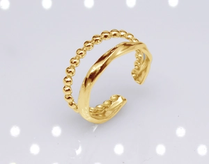 Detail shot of golden double-layer ring featuring bead patterns and wavy twisted surfaces