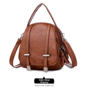 Detail view of brown vintage crossbody bag with pebbled texture and layered zippers