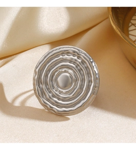 Detail of silver round stainless steel ring featuring textured concentric wave patterns