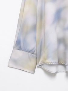 Detail of satin shirt sleeve with purple and yellow tie-dye patterns and soft luster
