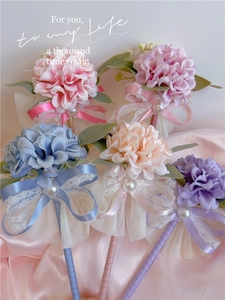 Detail showing artificial flower ball pens with satin ribbons and delicate lace trim