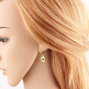 Gros plan d'une boucle d'oreille œil grec plaquée or avec zircon noir sur un mannequin
