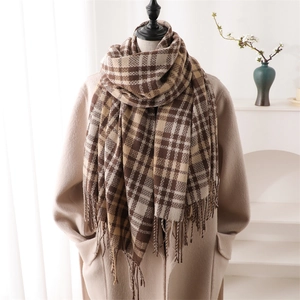 Close-up of brown plaid scarf with fringe on beige coat, autumn cashmere-like shawl